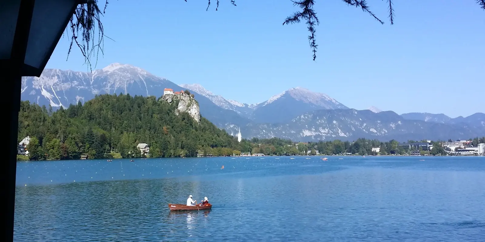 A rowing boat on Lake Bled with the castle and mountains in the background